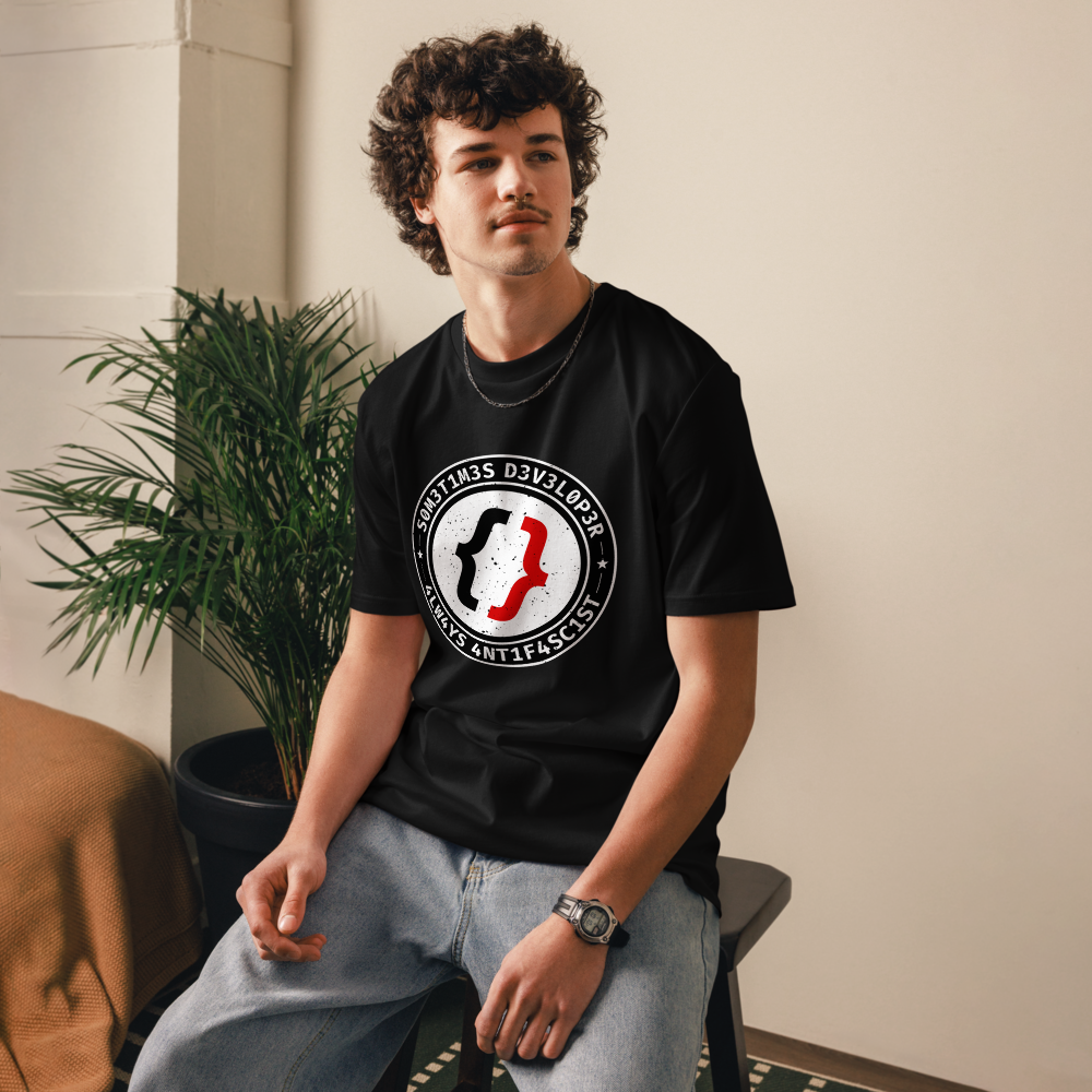 Image of a man with a black t-shirt with the text 'S0M3T1M3S D3V3L0P3R, 4LW4YS 4NT1F4SC1ST' written in circle that contains a curly brackets white and red